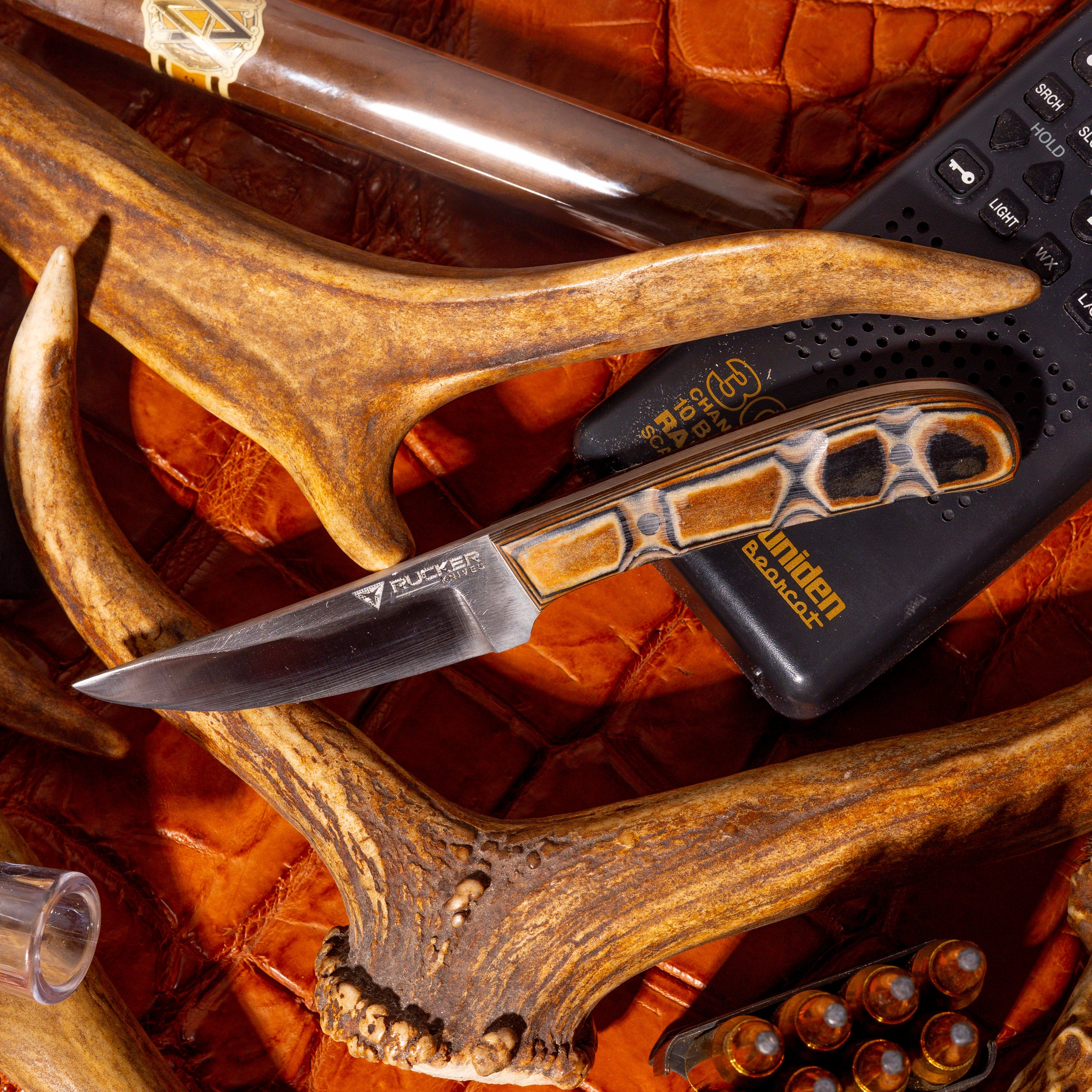 Rucker Knives IBK 4 in a staged enviroment with Stag, radio phone and alligator leather in the scene.